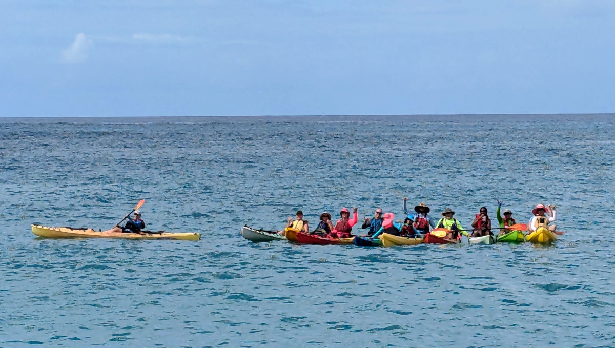 10 kayaks together giving shakas