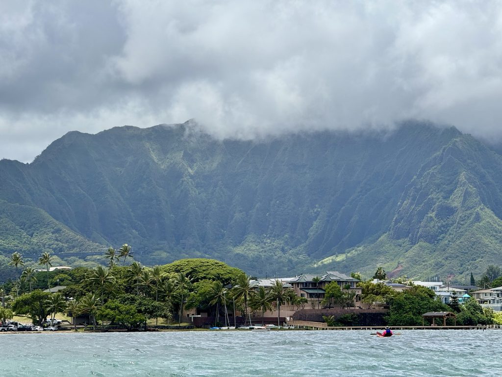Lone kayakers with lush green mountain in background