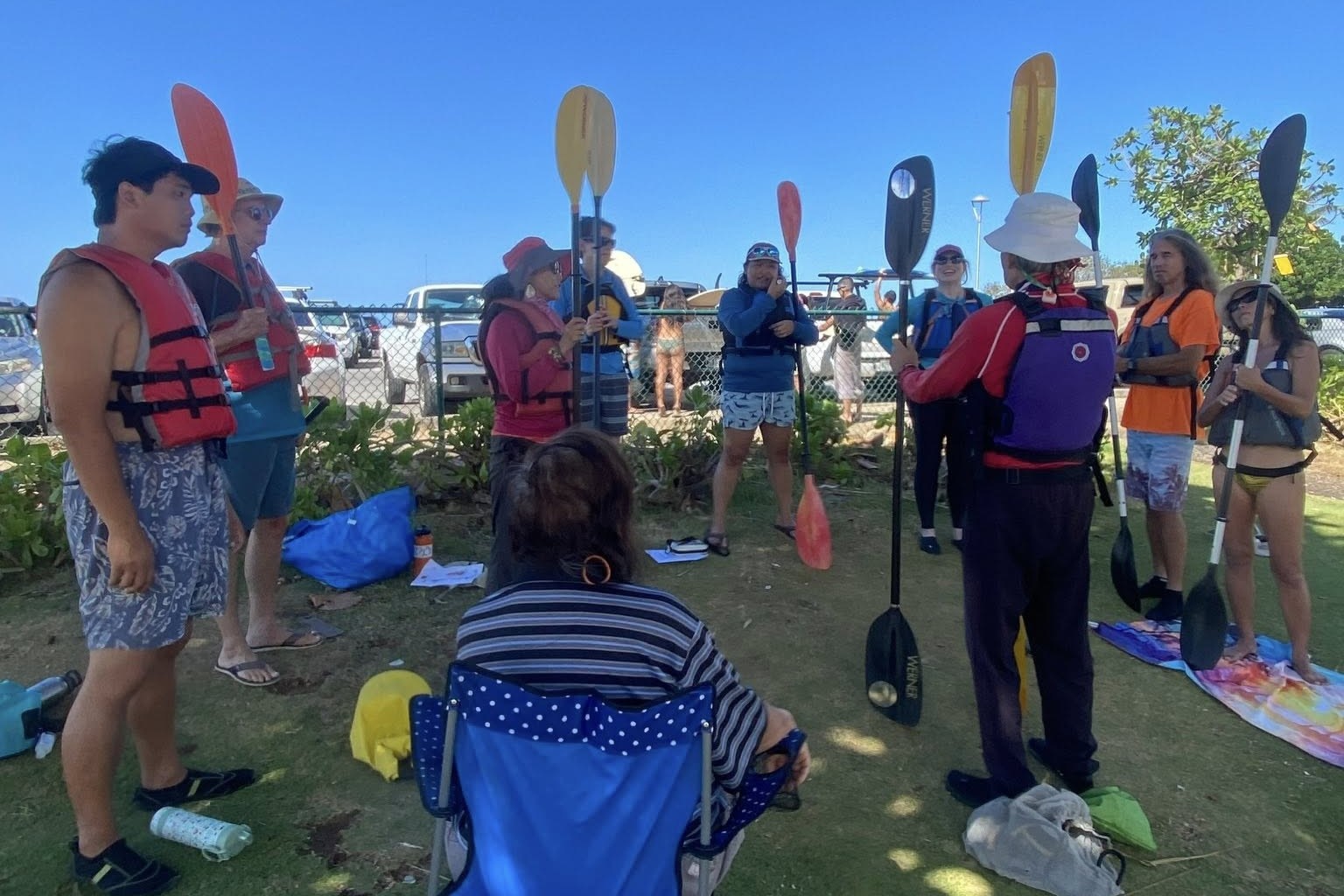 Clinic students in a circle holding paddles up