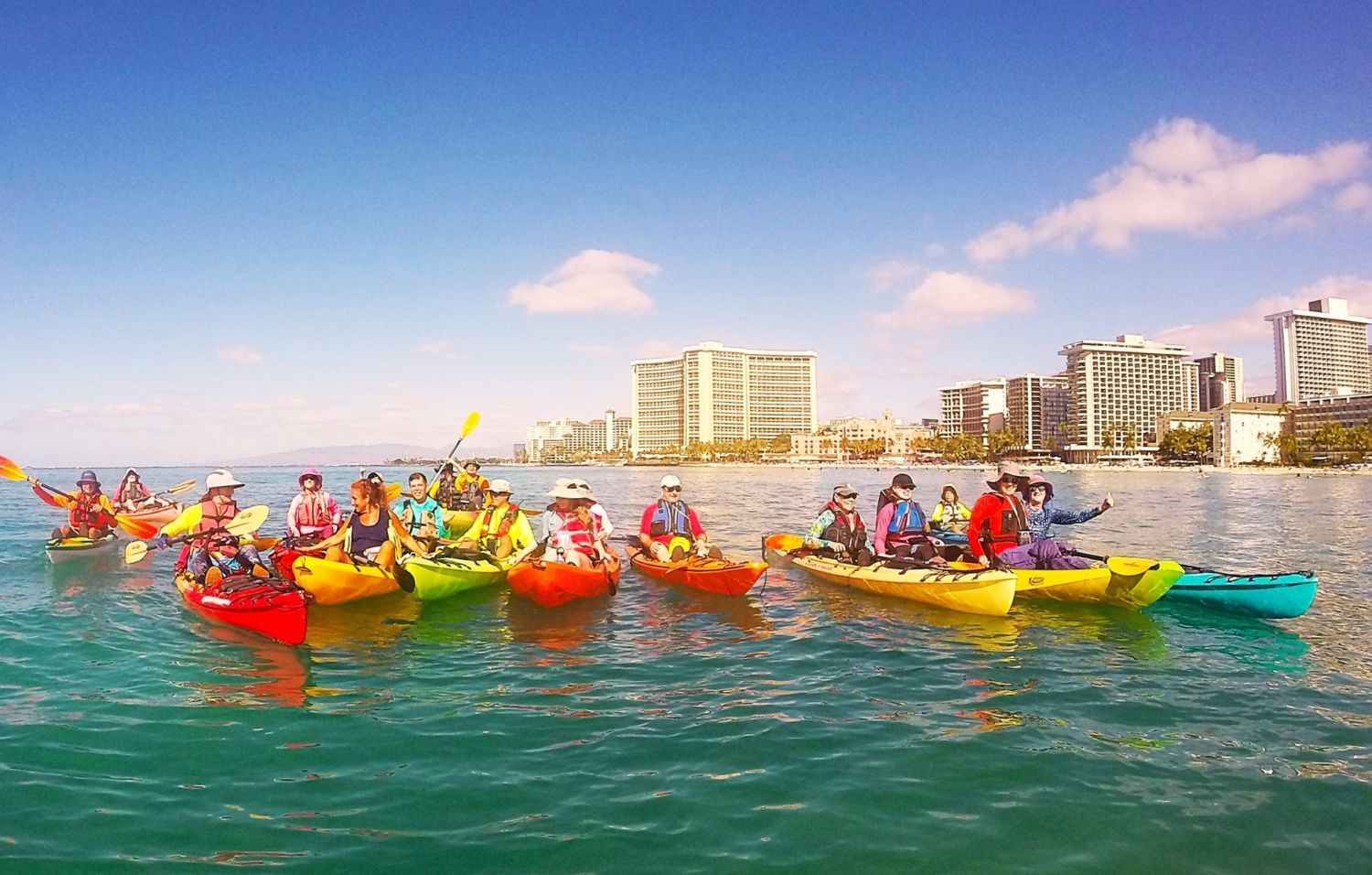 Group of kayakers posing in front of Waikiki hotels