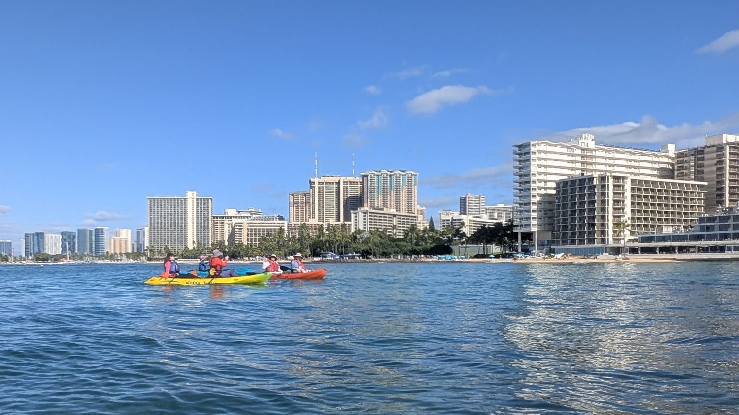 Two tandem kayaks pause outside of the Outrigger Reef hotel.