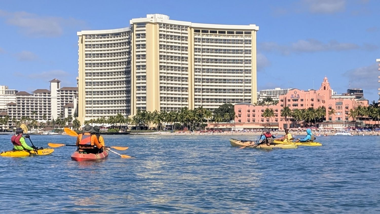 Four kayaks wait outside the pink Royal Hawaiian hotel