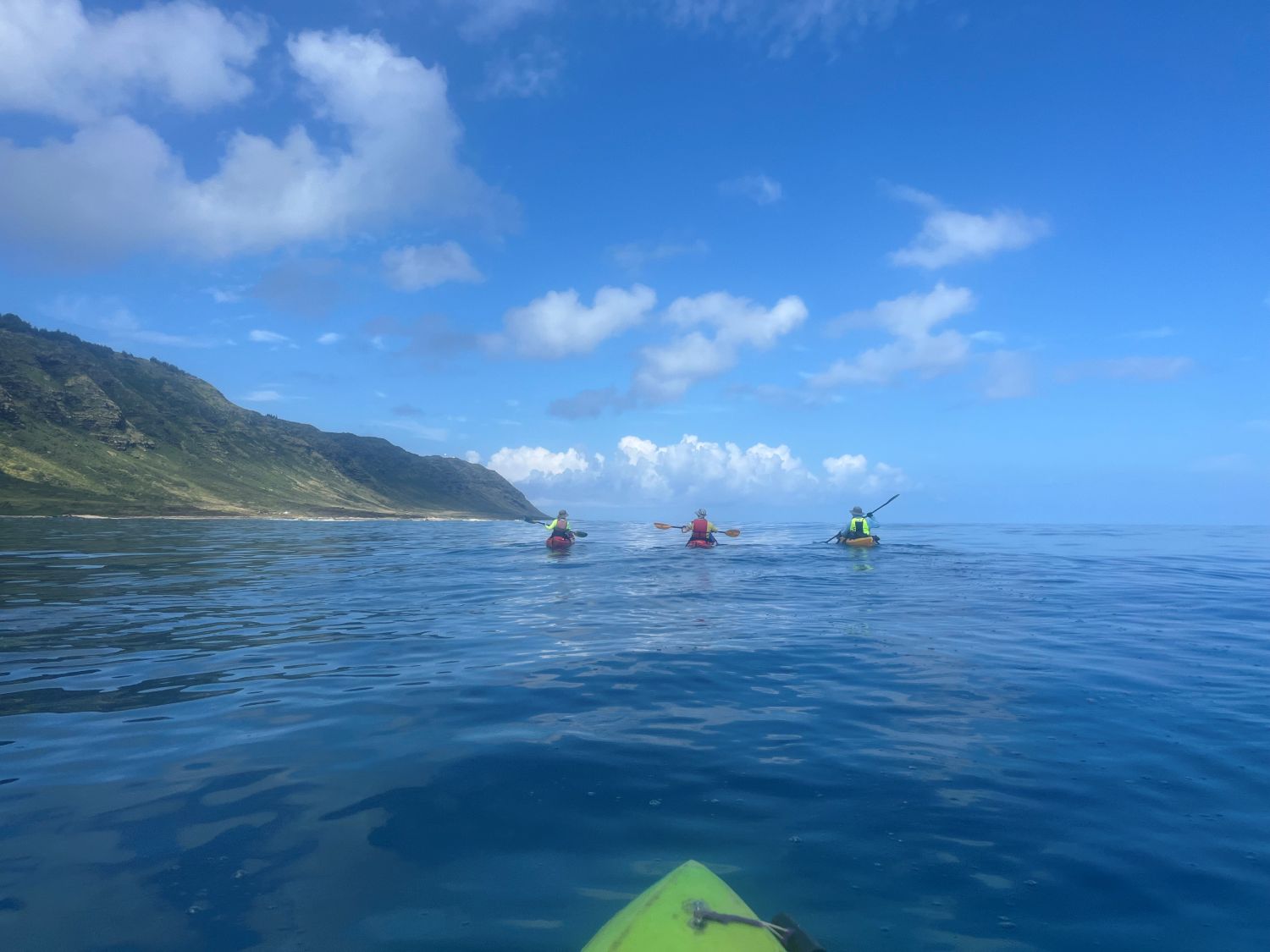 Three kayakers heading toward Kaena Point on very calm water